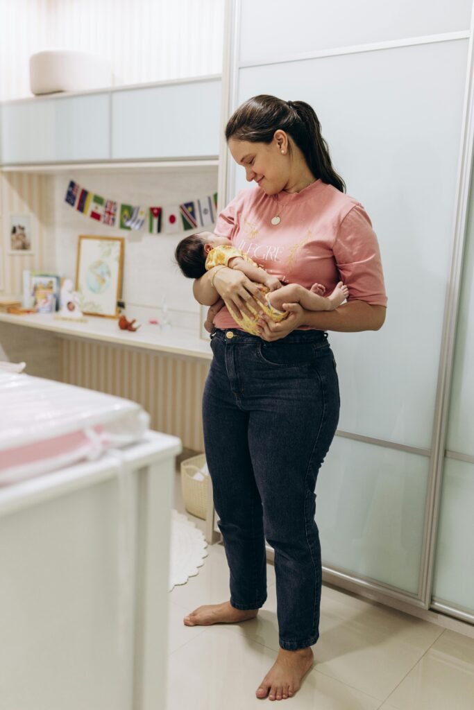 A mother lovingly cradles her newborn baby in a cozy room, depicting warmth and care.